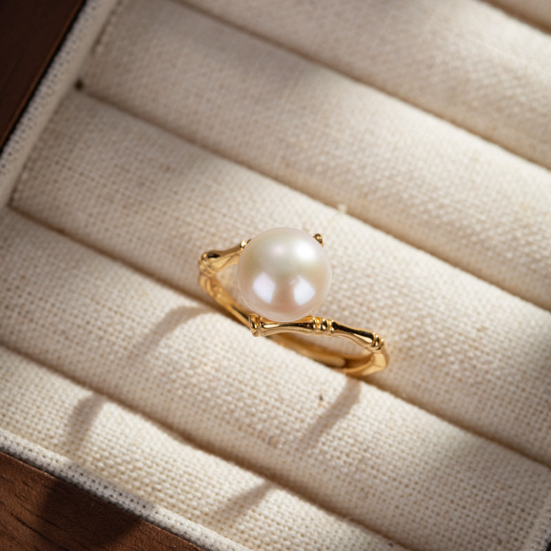 Bague élégante en argent plaqué or avec une perle blanche ronde, design inspired du bambou.