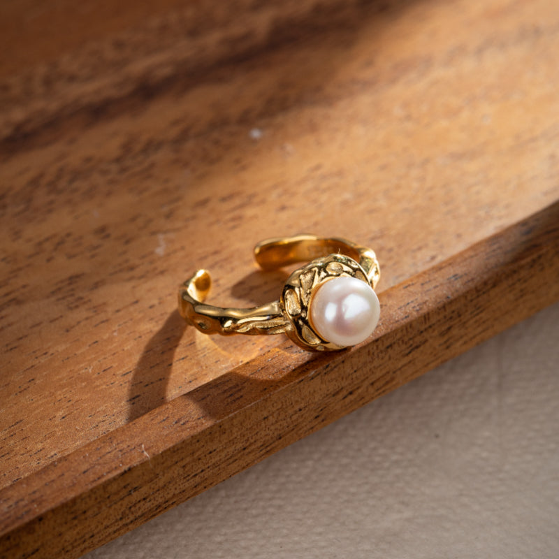 Bague en argent plaqué or sertie d'une perle blanche nacrée, design texturé, bijou ajustable.