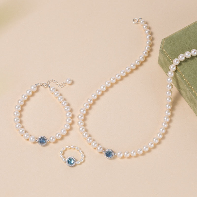 Ensemble de bijoux en argent sterling comprenant un collier, un bracelet et une bague ornés de perles d'eau douce et de pierres d'aigue-marine bleues.