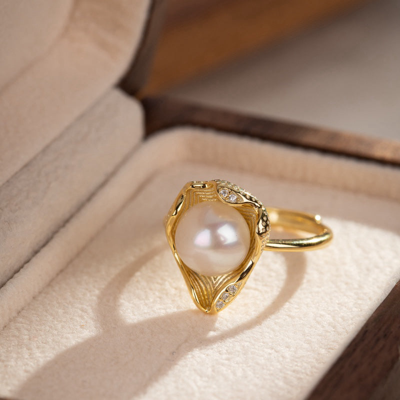 Bague en argent plaqué or sertie d'une perle nacrée et de petits cristaux, présentée dans un écrin en bois.