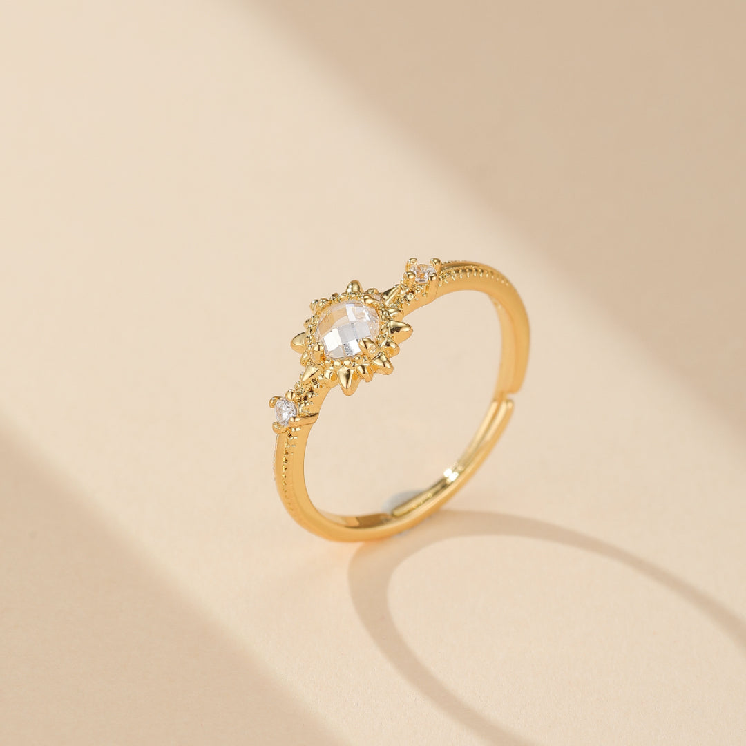 Bague ajustable Soleil en quartz clair, argent plaqué or, design fin et délicat. Cette bague brillante capture la lumière, le quartz rond étant serti dans une élégante structure solaire, apportant sérénité et une touche dorée à votre look.