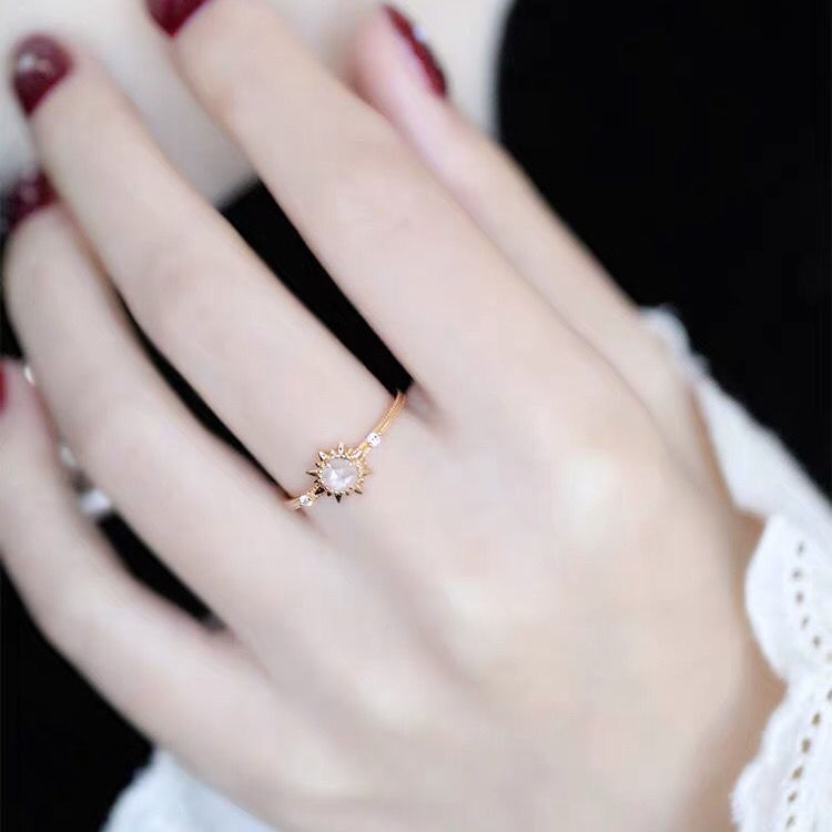 Bague fine en argent plaqué or avec un quartz clair central en forme de soleil et de petites pierres d'accent.