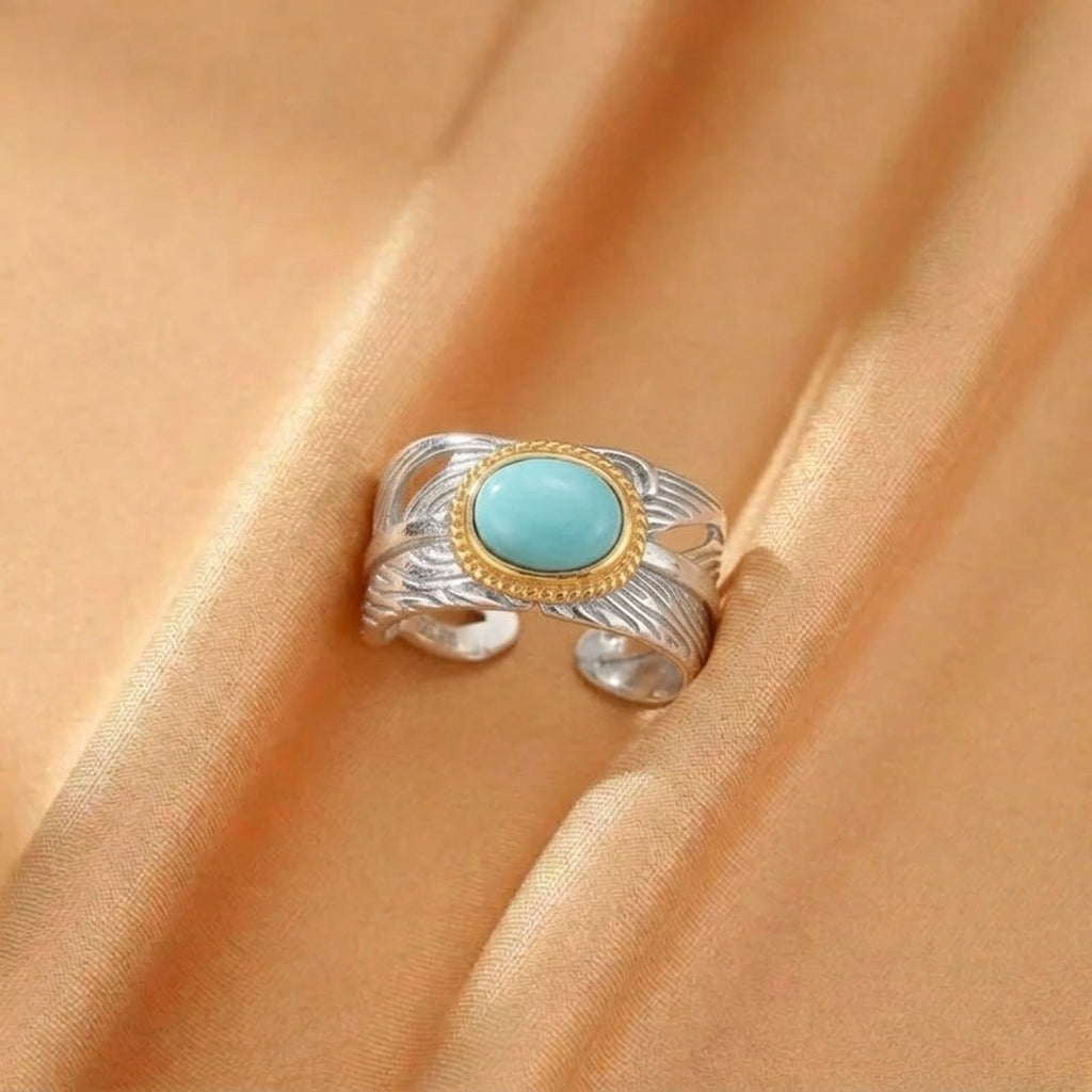 Bague réglable en argent et plaqué or ornée d'une turquoise ovale, design inspiré des plumes célestes.