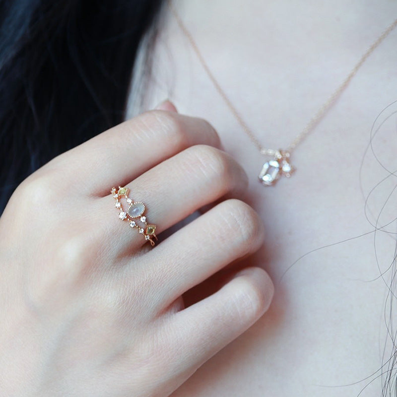 Bague Zircon Septentrion en argent plaqué or avec une pierre centrale bleutée entourée de petites pierres brillantes et d'étoiles.