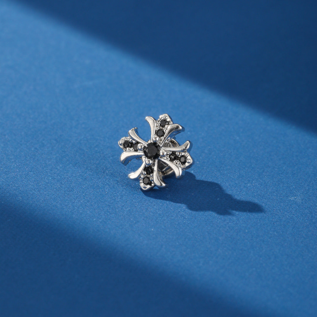 Side view of a Royal Spark men's earring, highlighting its stylized cross shape and magnetic system.
