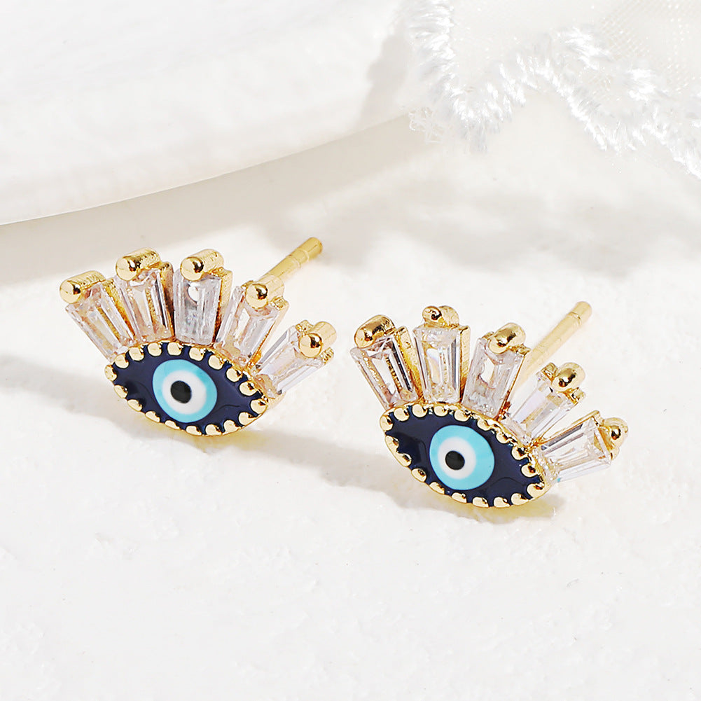 Boucles d'oreilles "Regard" en forme d'œil bleu avec des cristaux blancs et un fermoir doré.