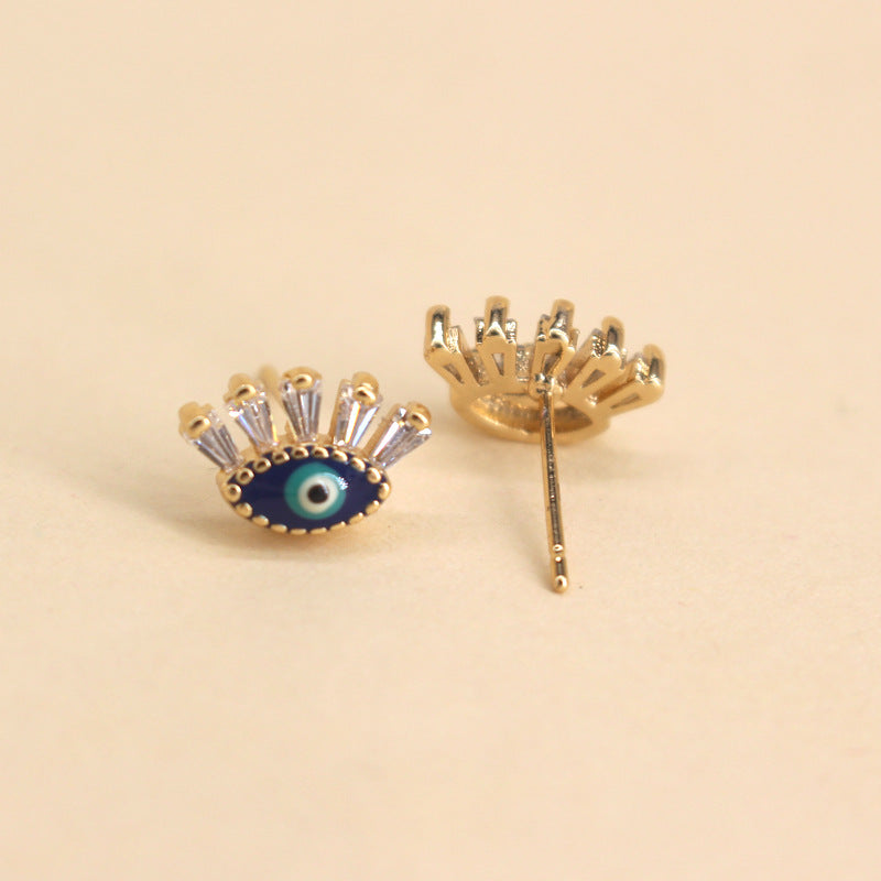 Boucles d'oreilles "Regard" en forme d'œil bleu et or, serties de cristaux blancs étincelants.