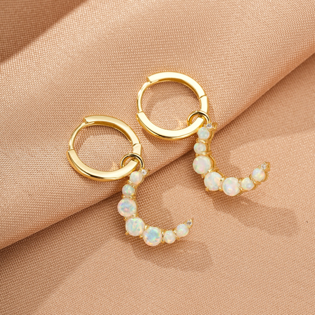 Boucles d'oreilles créoles en argent 925 plaqué or 18 carats ornées de petites opales blanches disposées en croissant de lune.