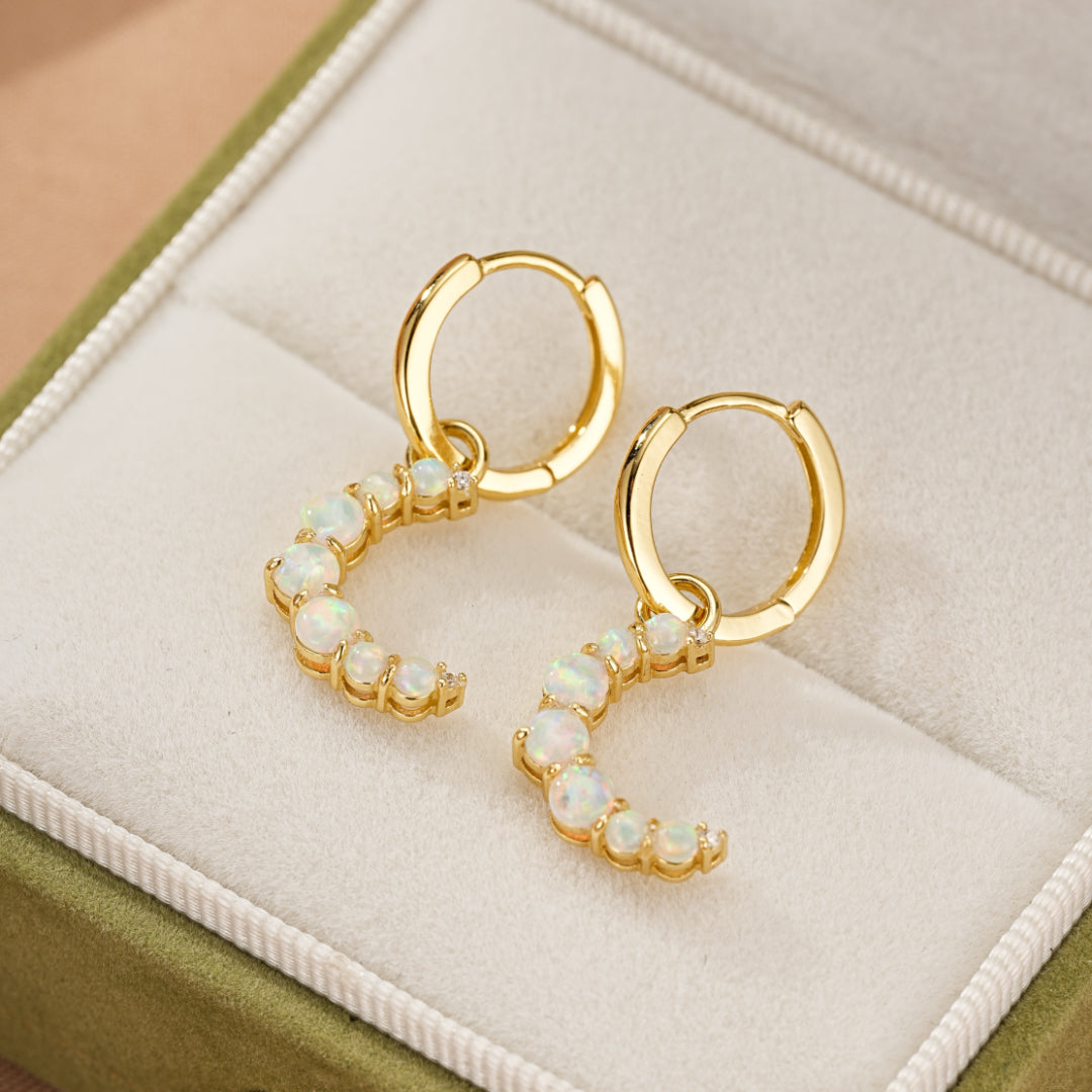 Boucles d'oreilles créoles plaquées or 18 carats avec demi-lunes d'opales blanches et petites pierres.