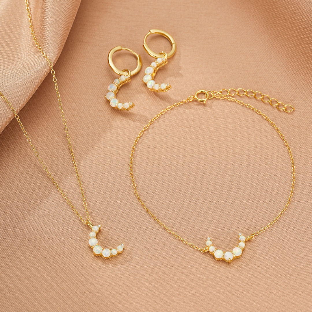 Ensemble de bijoux "Douce Lueur" en argent 925 plaqué or 18K, composé d'une paire de boucles d'oreilles créoles et d'un bracelet ornés de petites opales formant un croissant de lune délicat.