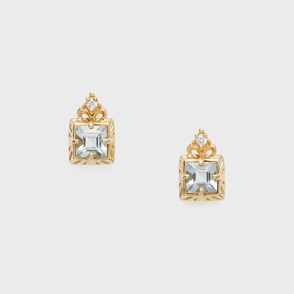 Paire de boucles d'oreilles plaqué or ornées d'une aigue-marine carrée centrale et d'un petit diamant sur le dessus, avec des détails gravés sur le cadre carré.