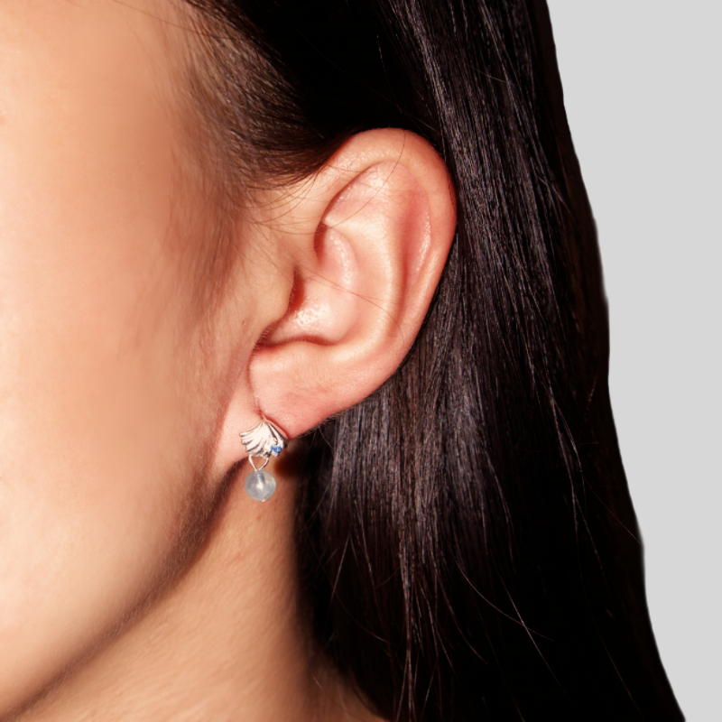 Boucles d'oreilles Étoile de l'Océan en argent ornées d'une aigue-marine et d'une perle bleutée, portées à l'oreille.
