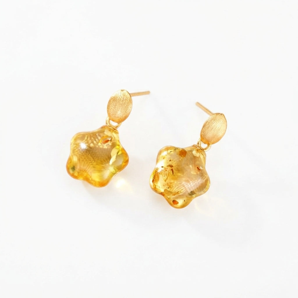 Boucles d'oreilles Murmure Doré en ambre véritable en forme de fleur avec attaches en argent plaqué or sur fond blanc