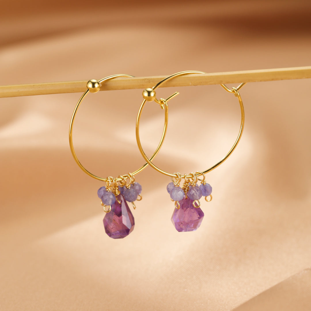 Paire de boucles d'oreilles créoles en argent plaqué or ornées d'améthystes brutes et de petites perles de tanzanite.