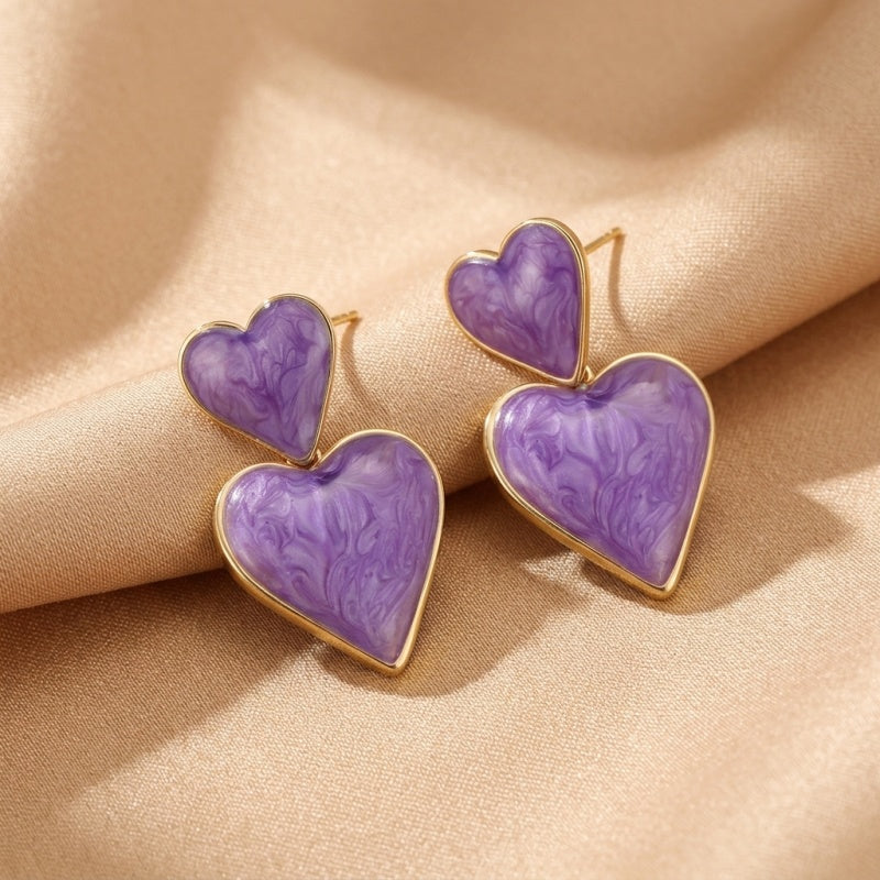 Boucles d'oreilles "Fragments d’Éclipse" en forme de cœurs doubles violets marbrés avec une finition dorée.