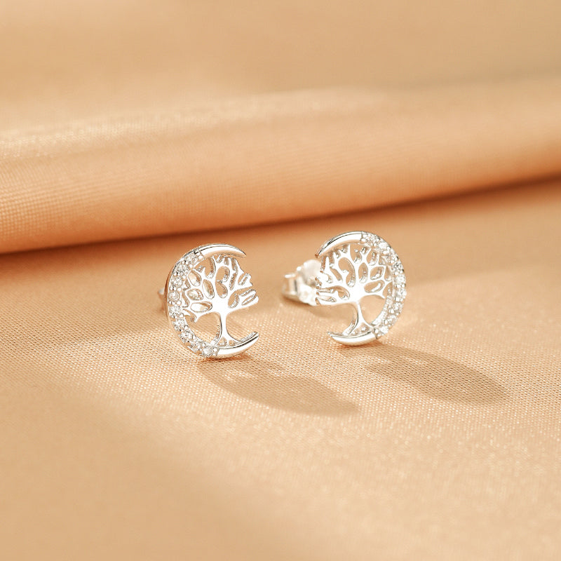 Boucles d'oreilles Arbre de Vie en argent S925, en forme de croissant de lune orné d'un arbre stylisé et de petites pierres scintillantes.