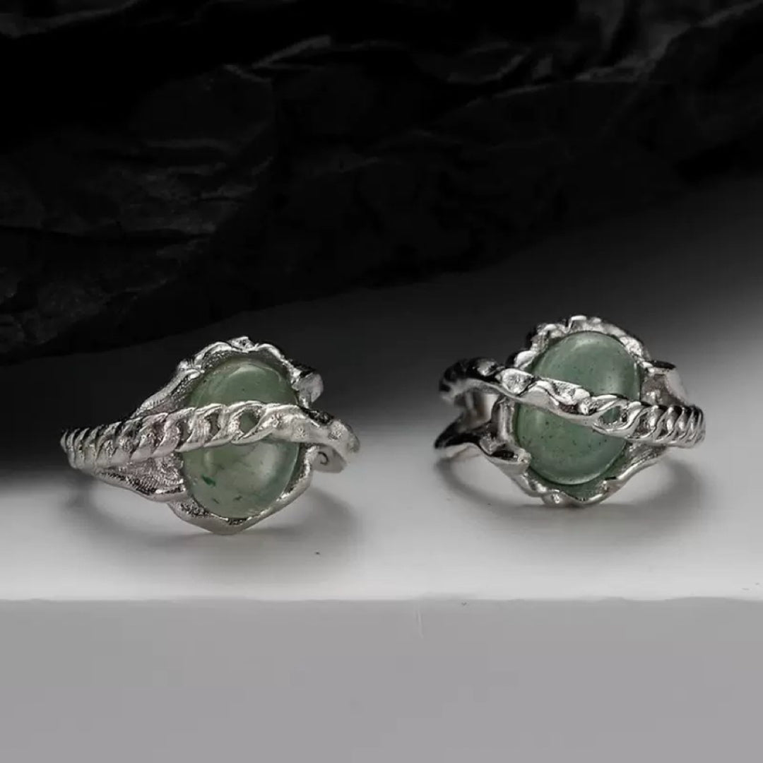 Boucles d'oreilles en argent avec des pierres d'aventurine vertes ovales serties dans un design torsadé unique.