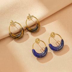 Boucles d'oreilles créoles en forme de croissant de lune avec pierres naturelles de lapis-lazuli bleu et œil-de-tigre doré, montées sur métal doré élégant.