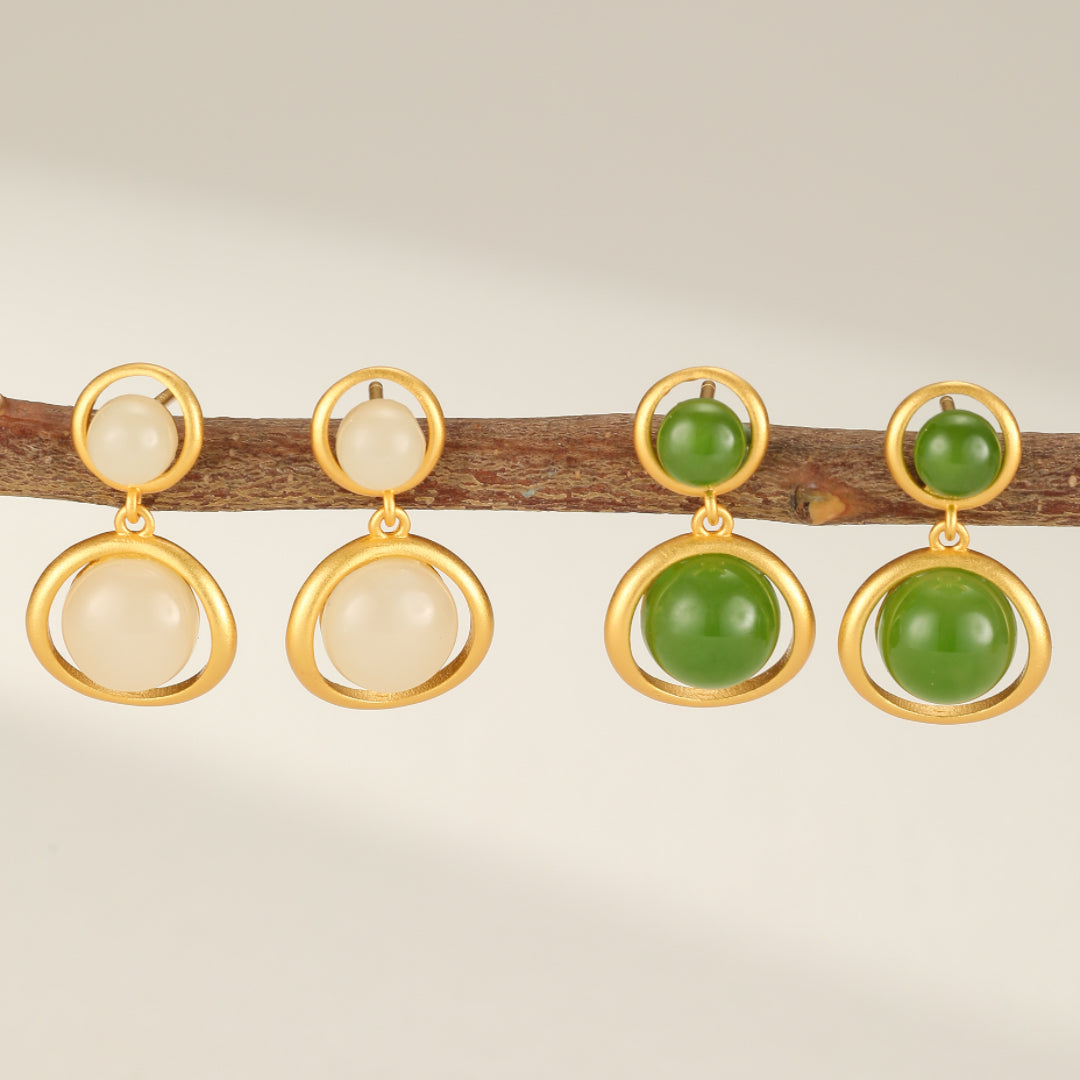 Boucles d'oreilles pendantes "Soleil Intérieur" en argent plaqué or, ornées de pierres de jade rondes blanches et vertes.