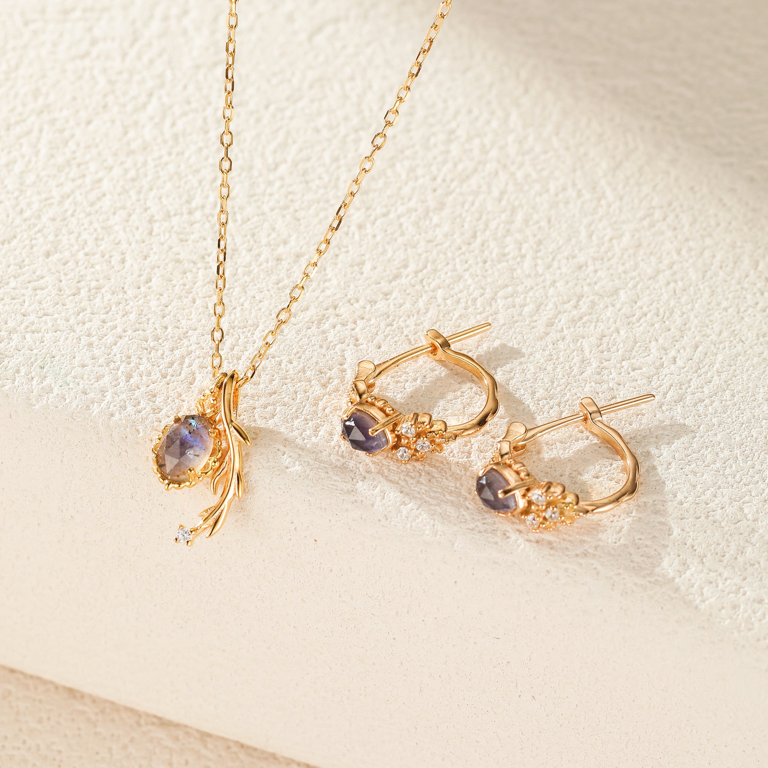 Ensemble de collier et boucles d'oreilles en plaqué or, sertis de pierres de labradorite et de cordiérite violettes, avec de petits diamants incrustés sur les boucles d'oreilles.