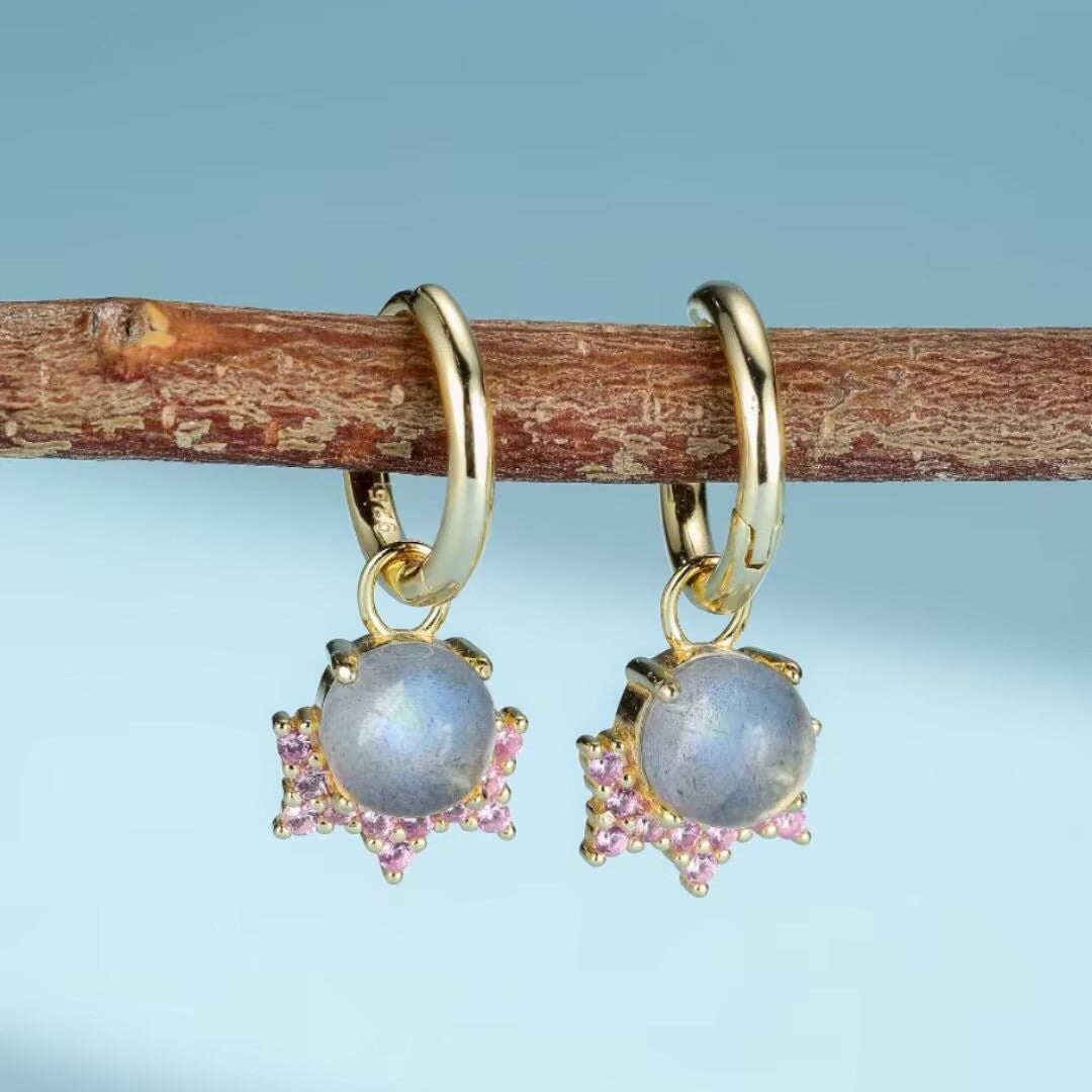 Paire de boucles d'oreilles créoles en argent plaqué or ornées de pierres de labradorite bleues et de petites pierres roses en forme d'étoile.