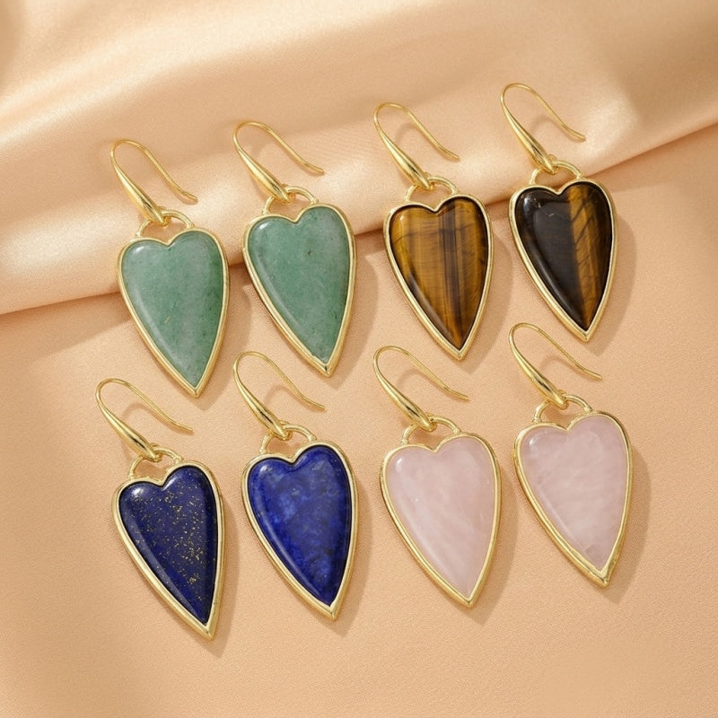 Boucles d'oreilles en forme de cœur avec des pierres bleues de Lapis Lazuli, des pierres roses de quartz rose, des pierres vertes d'aventurine et des pierres tigrées, ornées d'une monture dorée.