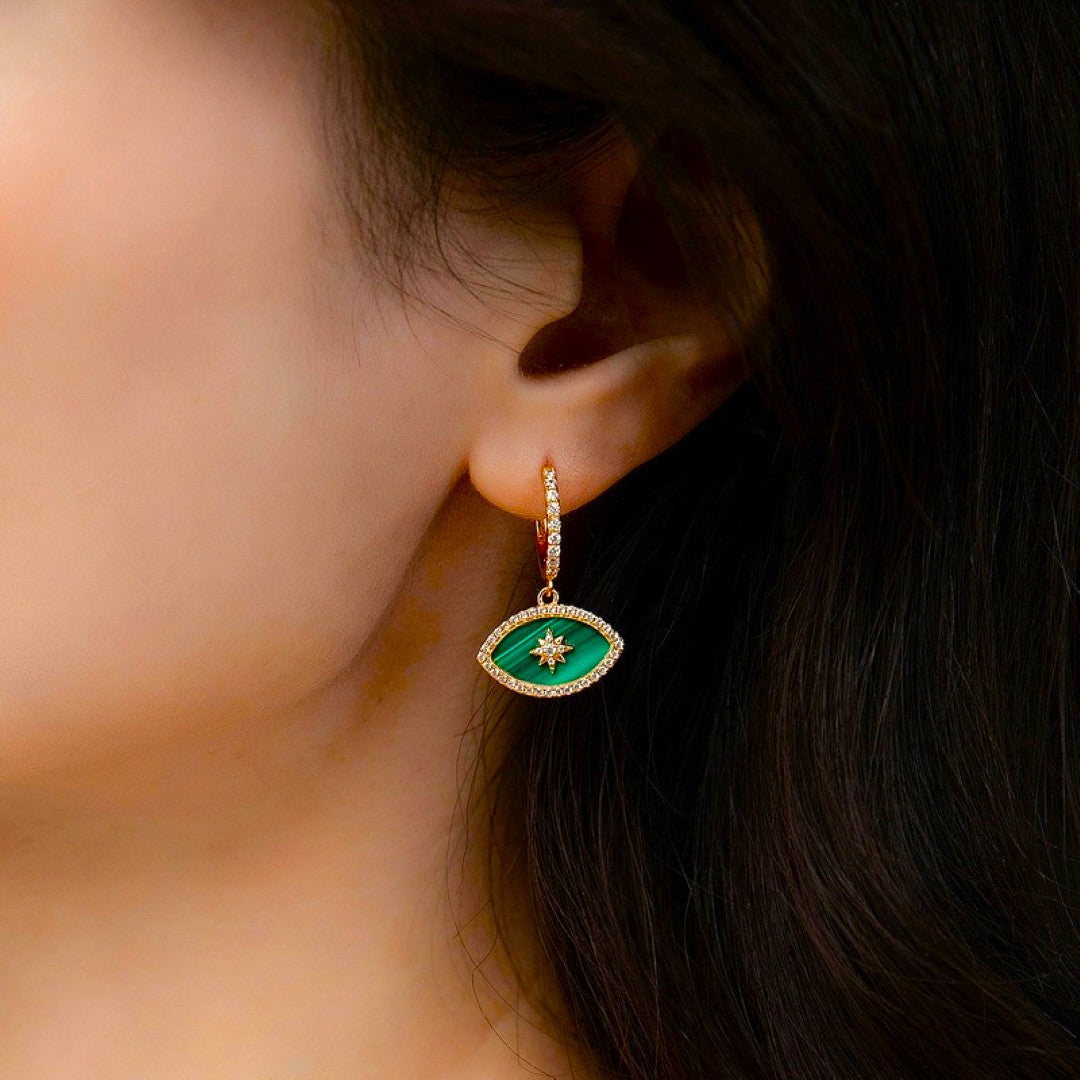 Boucle d'oreille œil en malachite avec une étoile au centre, bordure plaquée or et diamants.