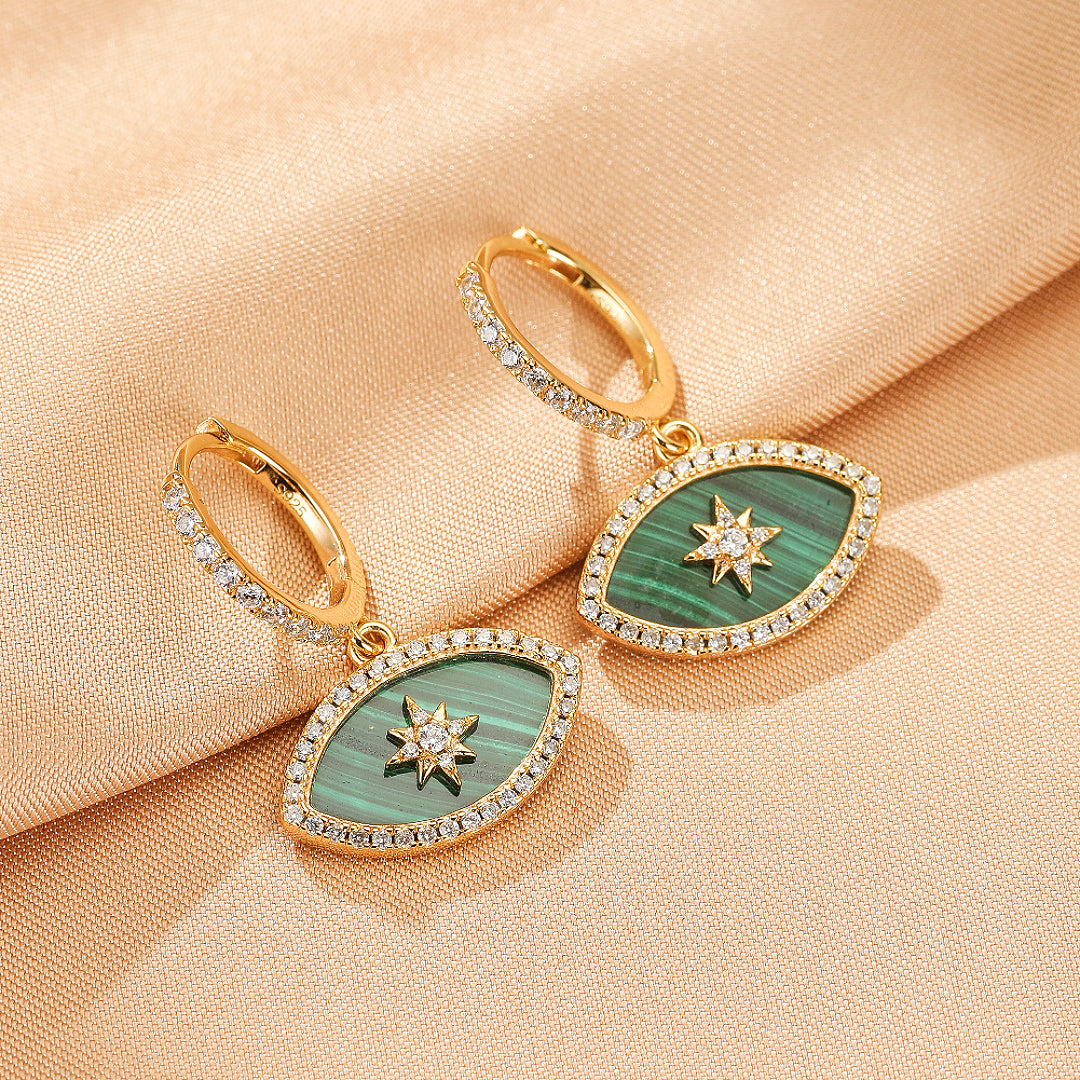 Paire de boucles d'oreilles pendantes en forme d'œil, plaquées or, ornées de malachite verte et d'une étoile au centre, bordées de petites pierres scintillantes.