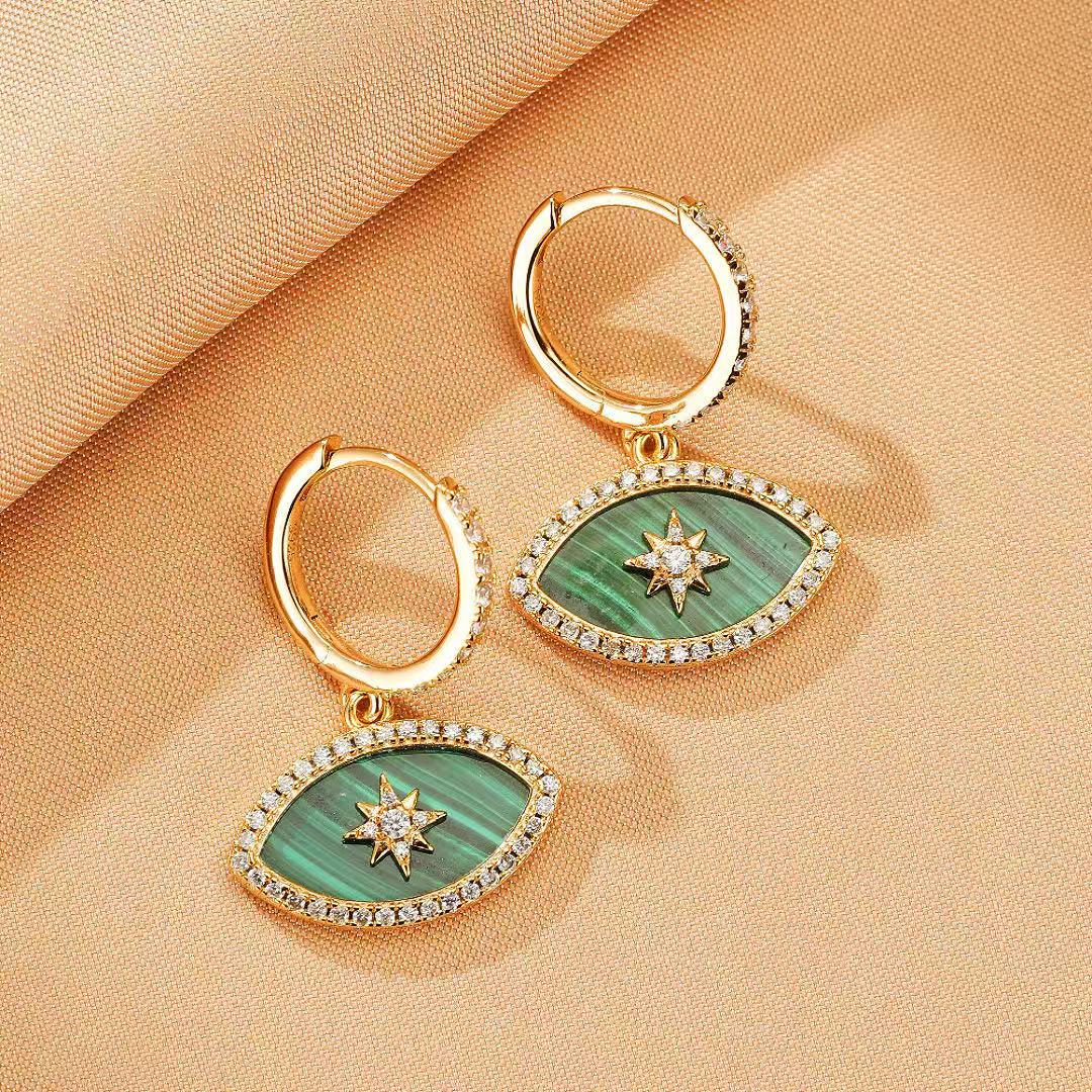 Paire de boucles d'oreilles pendantes en forme d'œil stylisé, ornées de malachite verte naturelle et d'une étoile scintillante au centre, bordées de zircons cubiques et montées sur une créole plaquée or.