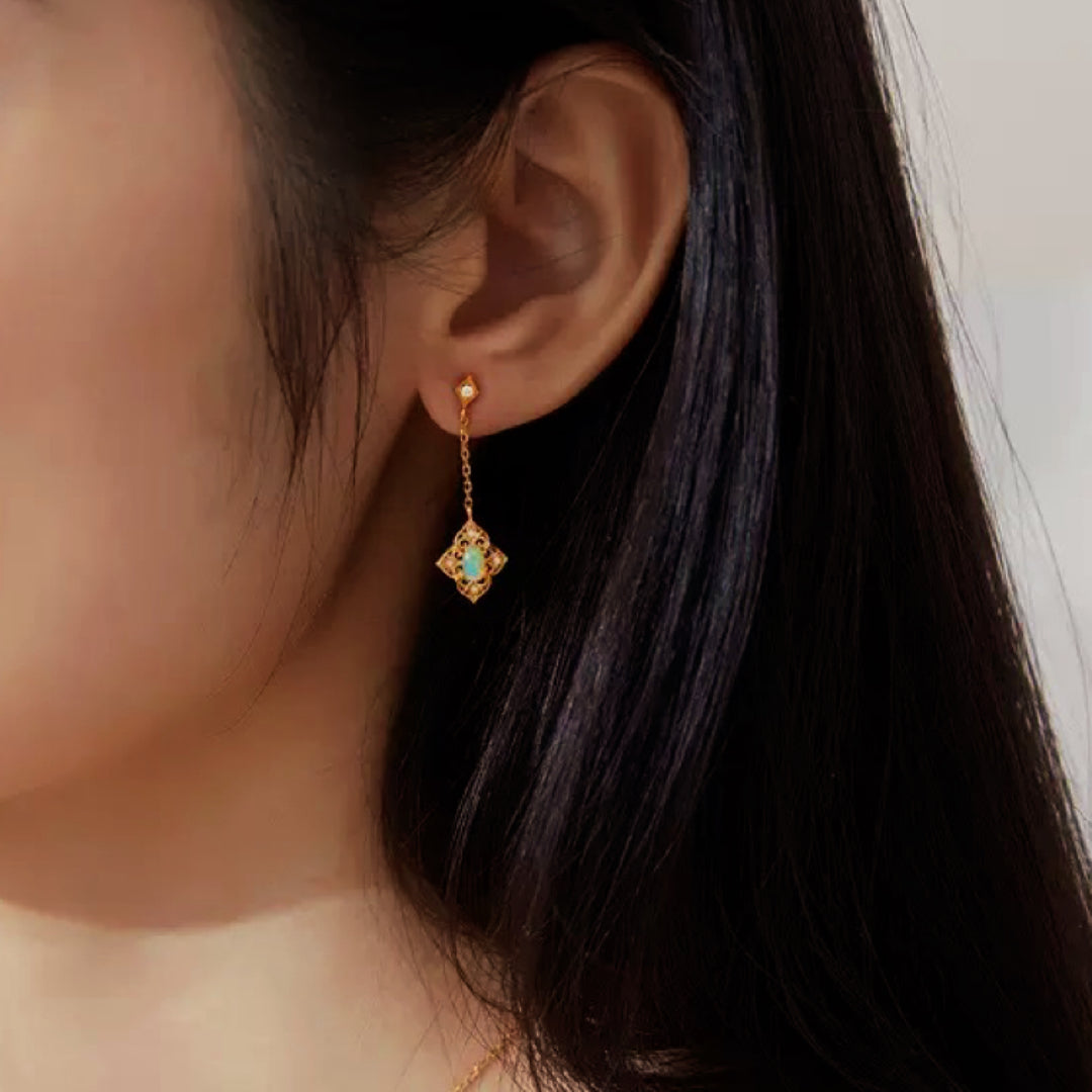 Boucles d'oreilles pendantes en argent plaqué or 10K avec une petite opale au centre d'un motif ajouré de forme carrée.