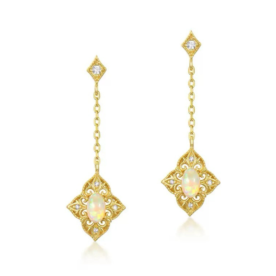 Paire de boucles d'oreilles pendantes en argent plaqué or 10 carats, ornées d'une opale centrale ovale et de petits diamants incrustés dans un design ajouré de style bohème.