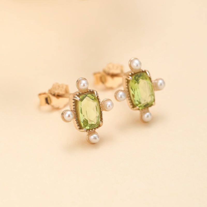 Boucles d'oreilles carrées en plaqué or ornées d'une pierre centrale péridot vert lumineux et entourées de petites perles blanches nacrées.