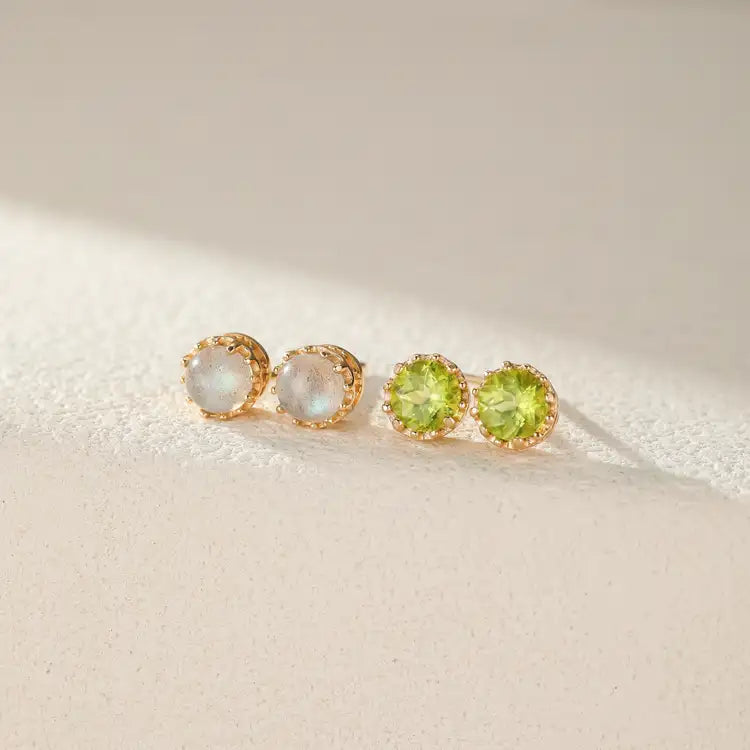 Boucles d'oreilles en argent plaqué or serties de pierres rondes bleutées (labradorite) et vertes (péridot), avec une monture finement ciselée rappelant des rayons de soleil.