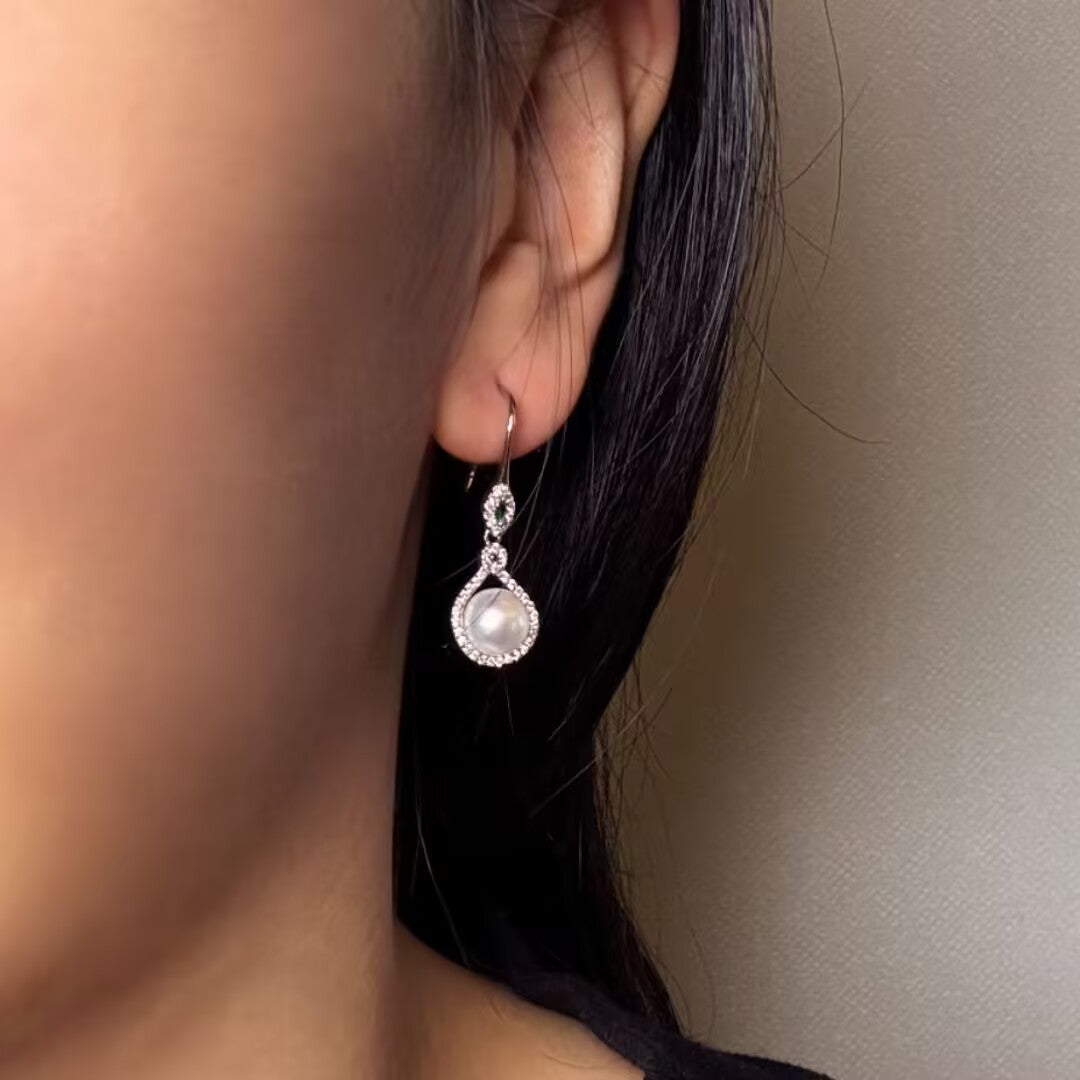 Boucles d’oreilles pendantes en argent 925 avec une perle nacrée et un entourage de zirconium