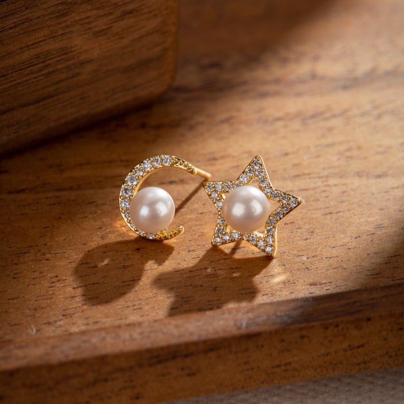 Paire de boucles d'oreilles plaqué or en forme de lune et d'étoile serties de perles et de zircons brillants.