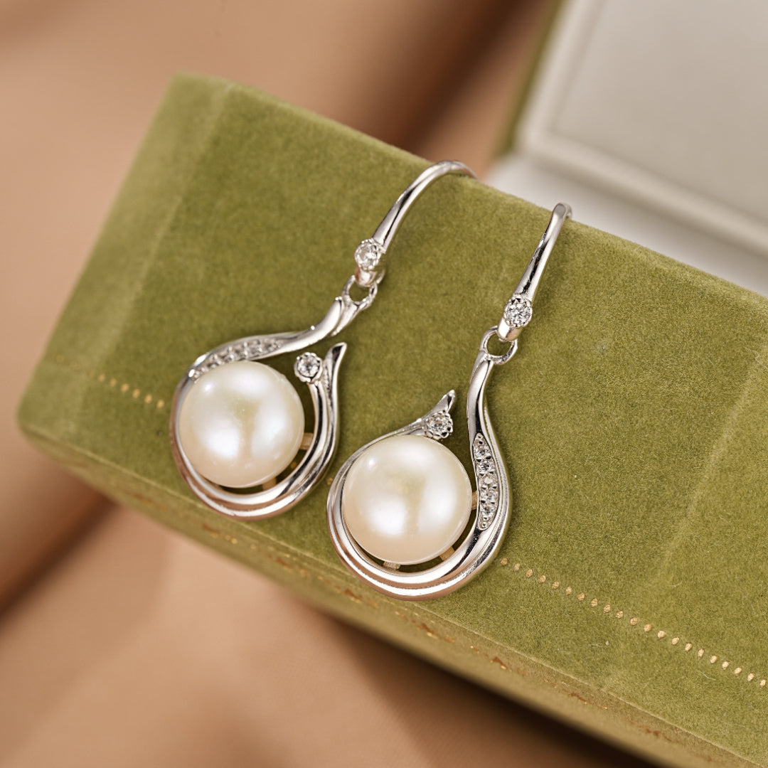 Boucles d'oreilles pendantes en argent ornées de perles et de petits cristaux scintillants, style goutte d'eau.