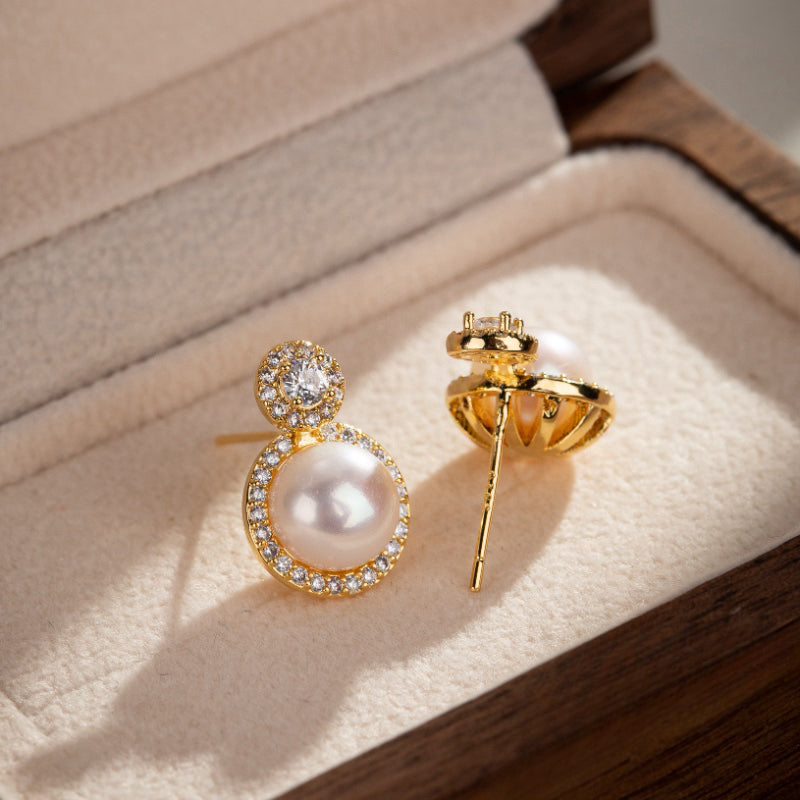 Boucles d'oreilles pendantes en or jaune serties de perles nacrées et d'oxydes de zirconium scintillants.
