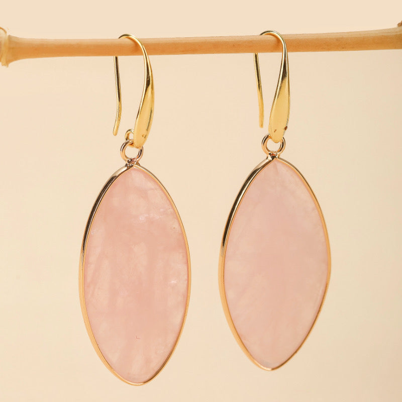 Boucles d'oreilles pendantes en quartz rose aux formes ovales et monture dorée.