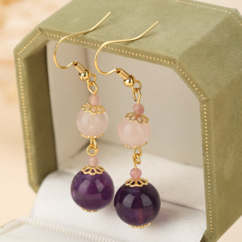 Boucles d'oreilles pendantes en quartz rose et améthyste, avec des perles rondes violettes et roses, ornées de détails dorés.