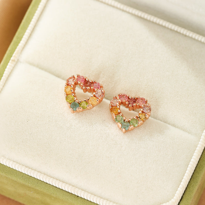 Boucles d'oreilles en argent en forme de cœur serties de tourmalines multicolores roses, oranges, jaunes et vertes, présentées dans une boîte à bijoux verte.