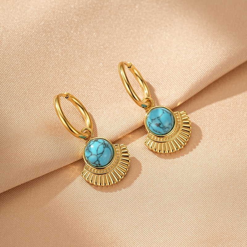 Paire de boucles d'oreilles en or avec une pierre bleue turquoise ronde sertie sur un pendentif doré en forme d'éventail avec des détails côtelés.