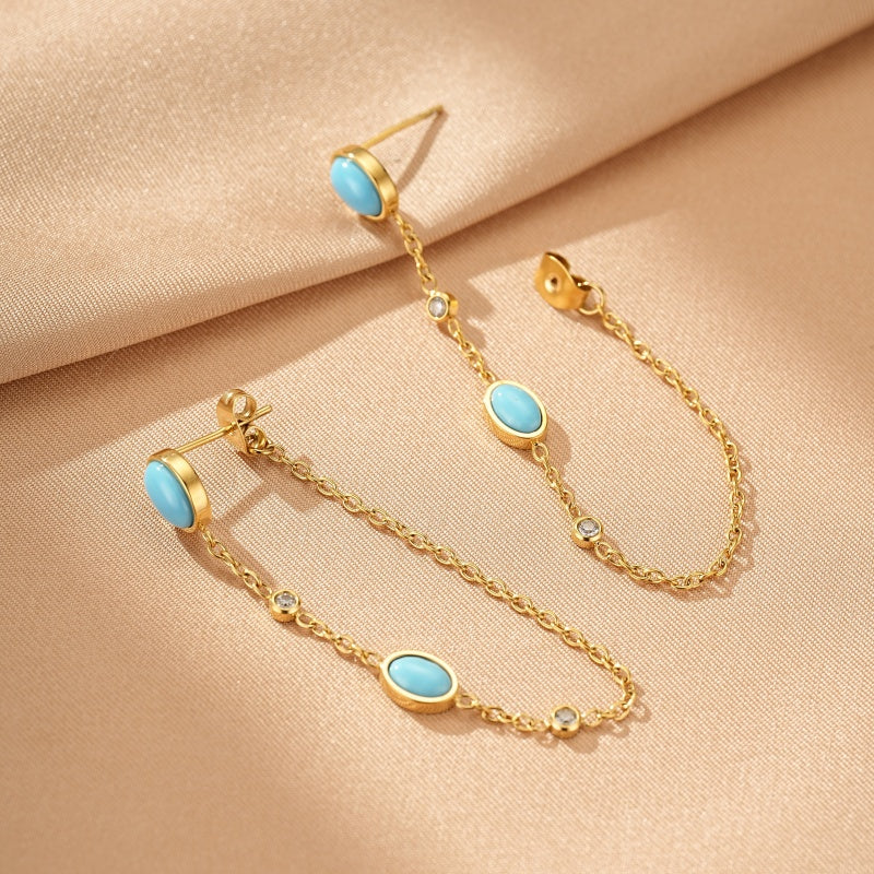 Boucles d'oreilles pendantes en or avec turquoise et petites pierres de zircon, style minimaliste.