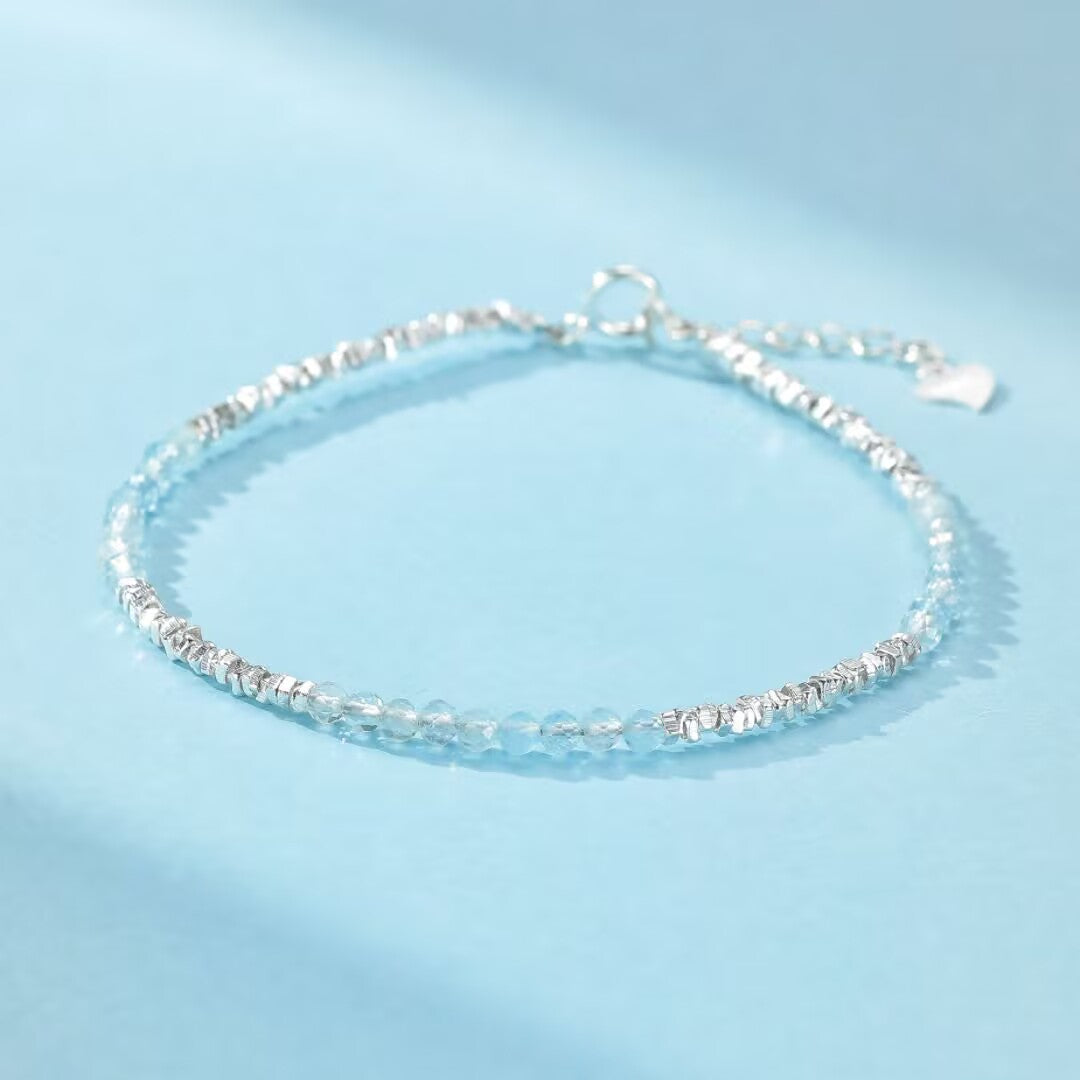 Bracelet "Brume Matinale" en argent 925 avec petites pierres d'aigue-marine facettées et éléments argentés texturés.