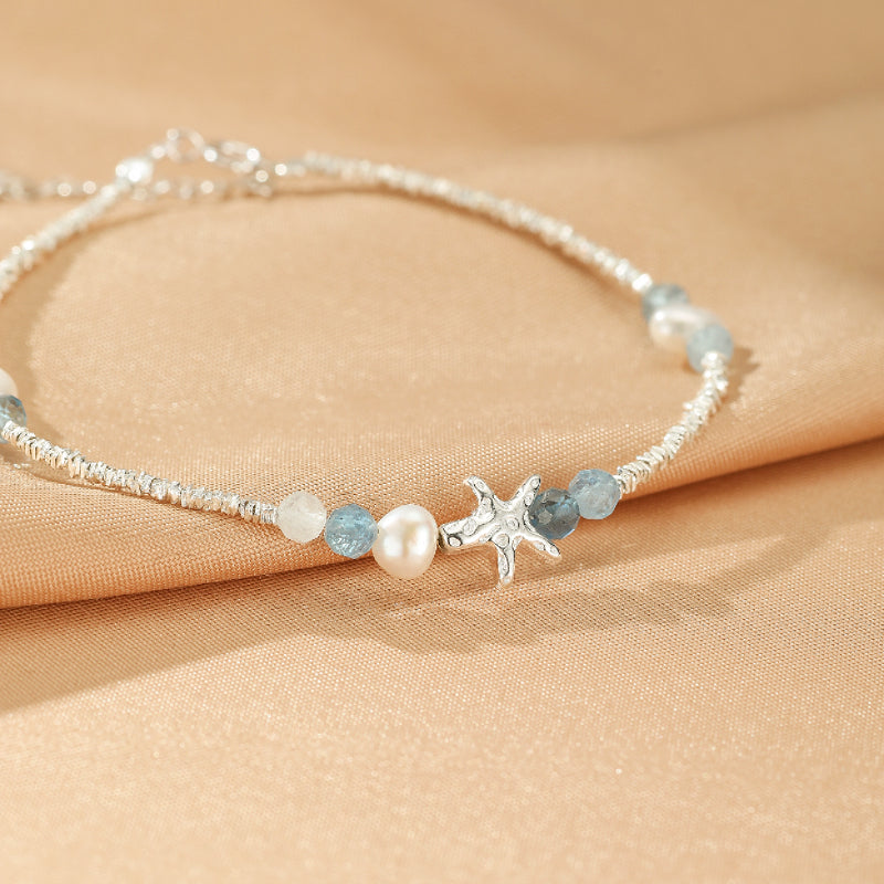 Bracelet "Vol Marin" en argent S925 avec perles d'aigue-marine, perle blanche et breloque étoile de mer.