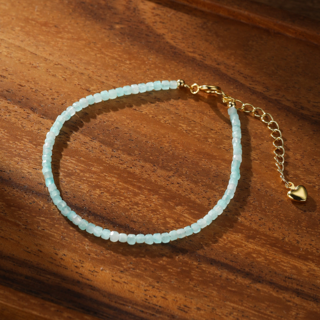 Bracelet fin en amazonite bleu pâle avec fermoir et chaînette en plaqué or, orné d'un petit cœur doré.