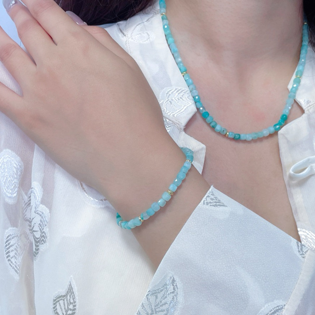 Ensemble de bijoux "Reflet d'Aurore" comprenant un bracelet et un collier assortis, fabriqués avec des perles d'amazonite bleues et des accents dorés.