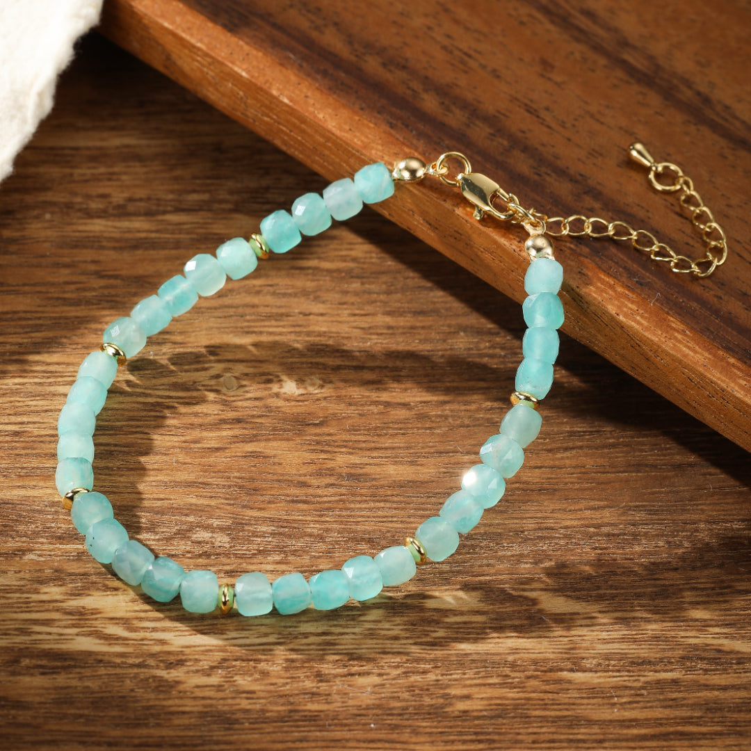 Bracelet en amazonite naturelle aux perles facettées bleu-vert pâle, rehaussé de petites perles dorées et d'une chaîne d'extension dorée.