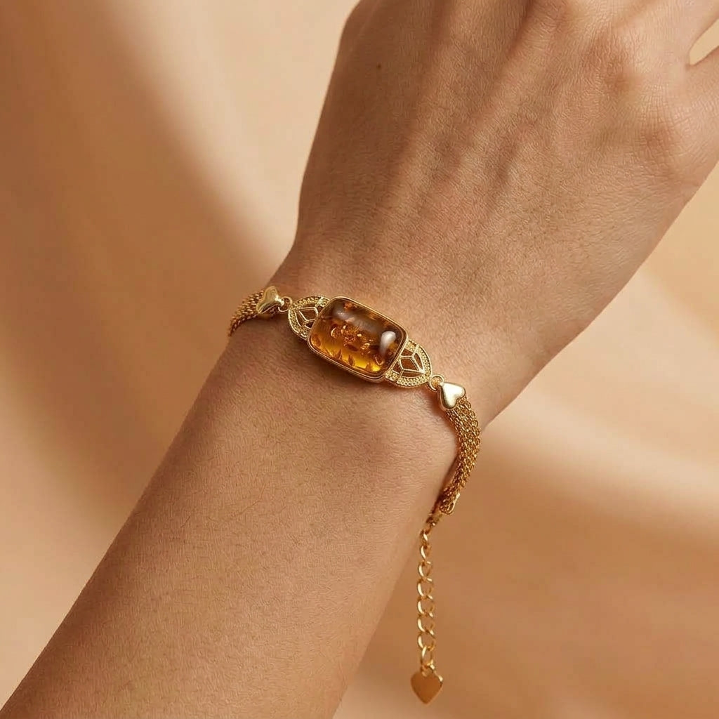 Bracelet raffiné en ambre véritable et argent plaqué or, modèle Feu Ancestral porté au poignet sur fond beige