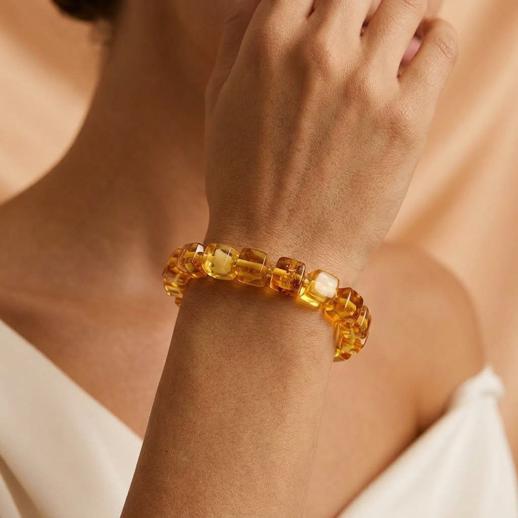 Bracelet Héritage Solaire composé de perles d'ambre naturelles aux reflets dorés porté au poignet