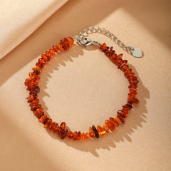 Bracelet en perles d'ambre naturel aux tons chaleureux, modèle Soleil Éternel avec fermoir en métal argenté et chaînette d'ajustement.